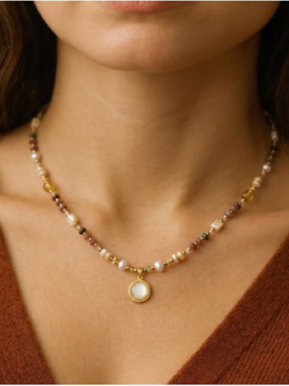Multi-colored beaded necklace with gold accents and a pendant